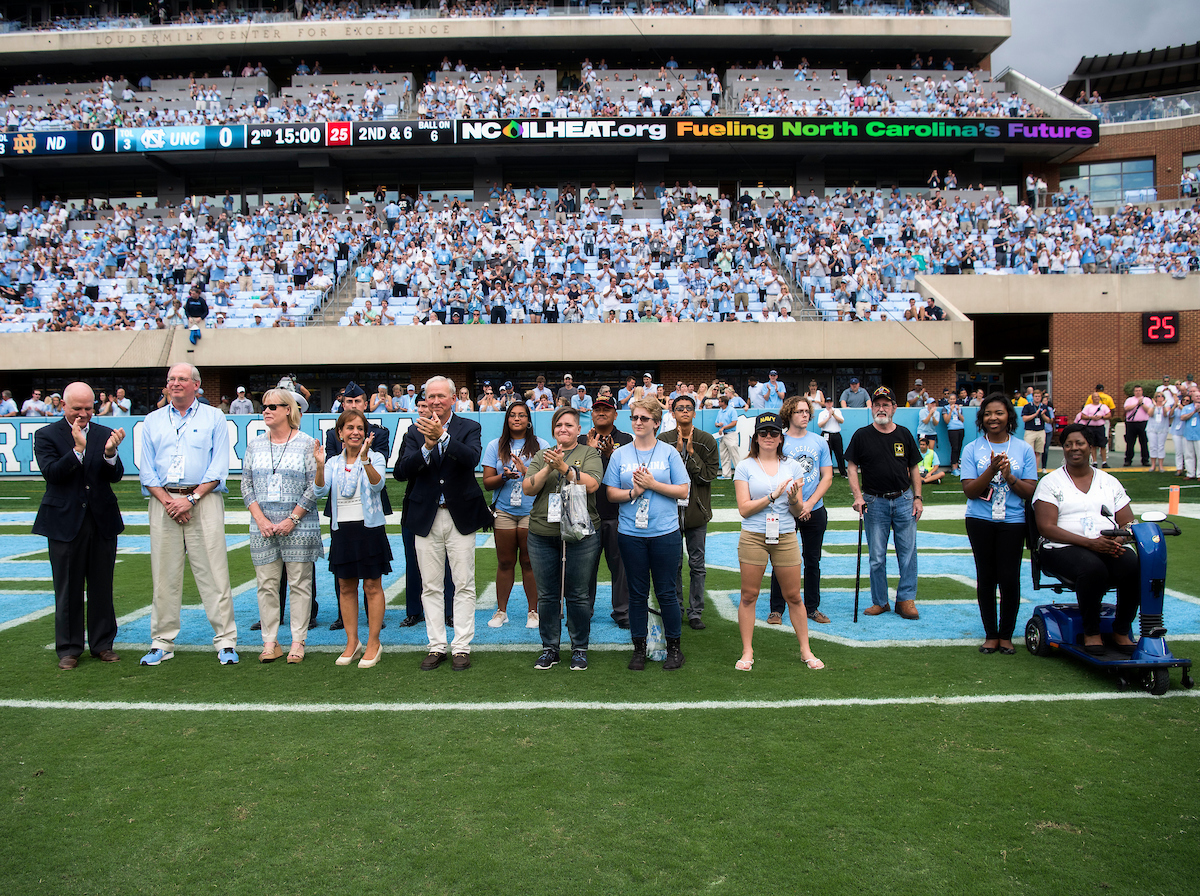 Steve and Debbie Vetter join University leaders and students on the field at Kenan Stadium to announce the Red, White and Carolina Blue Challenge.