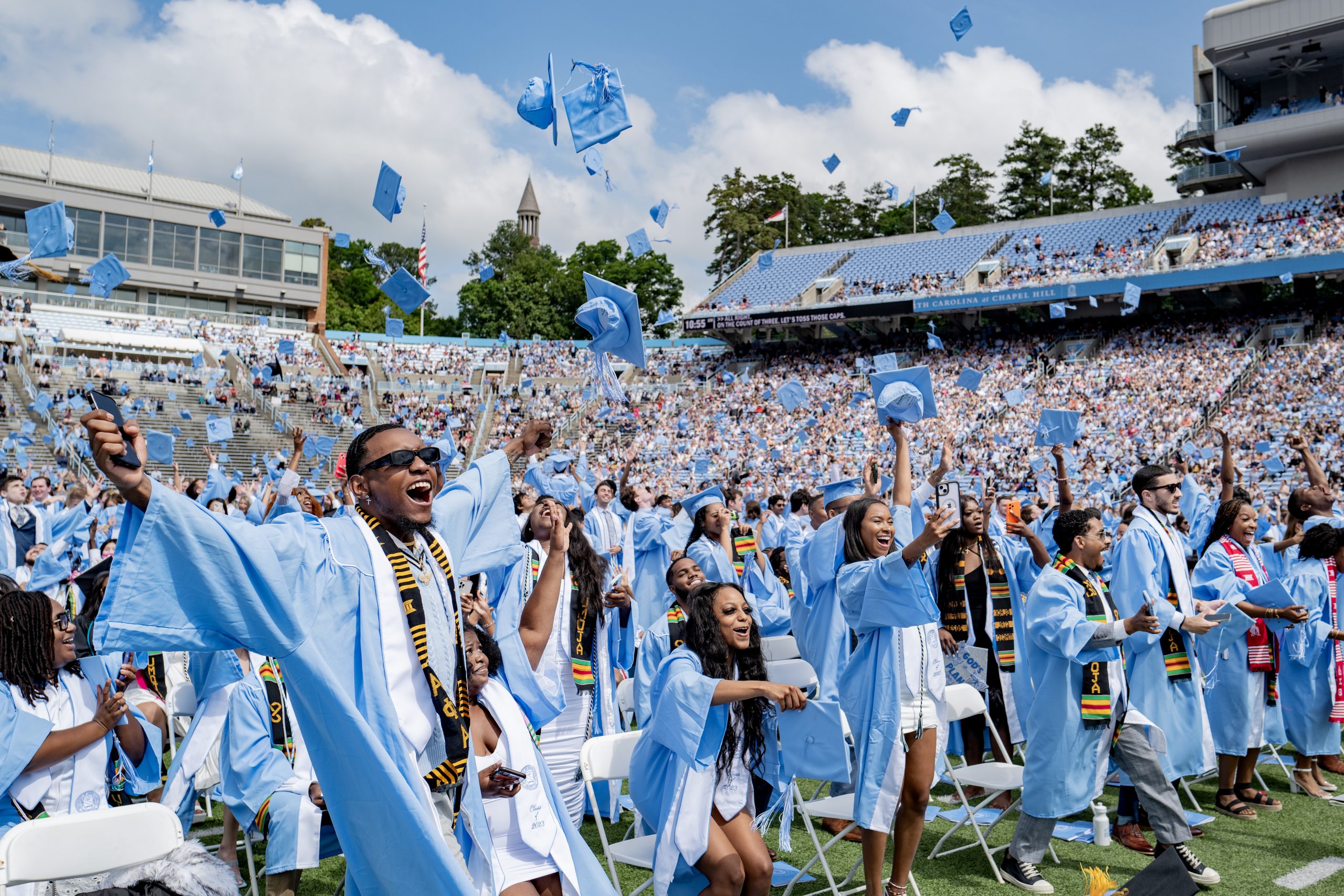 Members of the class of 2023 throw their graduation caps into the air at Kenan Stadium